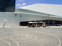 A dynamic atmosphere exists in front of an entrance to the CityLife Shopping District in Milan, Italy, on May 27, 2023. (