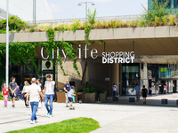 A dynamic atmosphere exists in front of an entrance to the CityLife Shopping District in Milan, Italy, on May 27, 2023. (