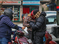 An Indian security personnel checks the identity cards of motorcyclists during a gun battle between militants and security forces on the out...