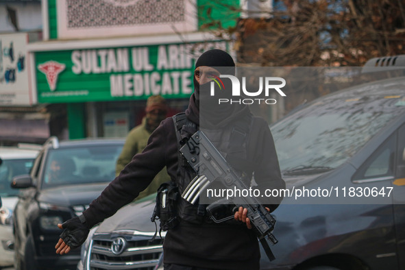 An Indian security personnel guards a road during a gun battle between militants and security forces on the outskirts of Srinagar, Jammu and...