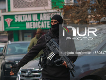 An Indian security personnel guards a road during a gun battle between militants and security forces on the outskirts of Srinagar, Jammu and...