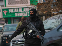 An Indian security personnel guards a road during a gun battle between militants and security forces on the outskirts of Srinagar, Jammu and...