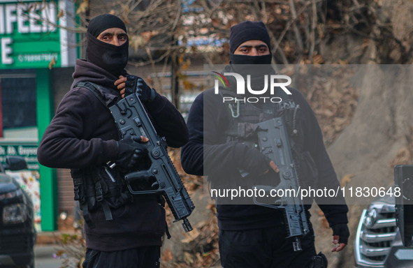 An Indian security personnel stands guard along a road during a gun battle between militants and security forces on the outskirts of Srinaga...