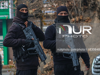 An Indian security personnel stands guard along a road during a gun battle between militants and security forces on the outskirts of Srinaga...