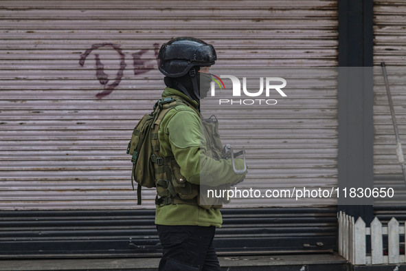 An Indian security personnel guards near the site of a gun battle between militants and security forces on the outskirts of Srinagar, Jammu...