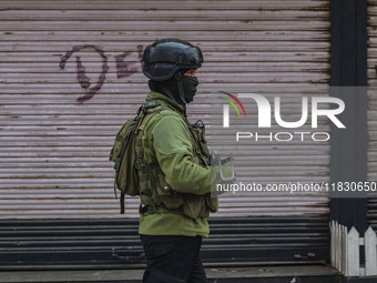 An Indian security personnel guards near the site of a gun battle between militants and security forces on the outskirts of Srinagar, Jammu...