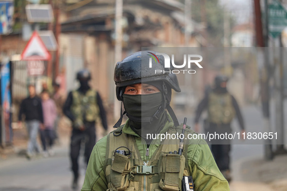 An Indian security personnel guards near the site of a gun battle between militants and security forces on the outskirts of Srinagar, Jammu...