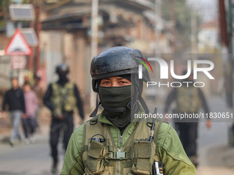 An Indian security personnel guards near the site of a gun battle between militants and security forces on the outskirts of Srinagar, Jammu...