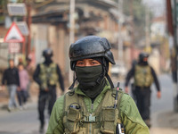 An Indian security personnel guards near the site of a gun battle between militants and security forces on the outskirts of Srinagar, Jammu...