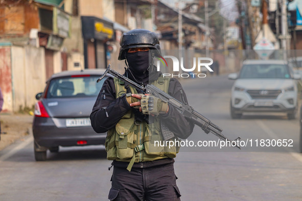 An Indian security personnel guards near the site of a gun battle between militants and security forces on the outskirts of Srinagar, Jammu...