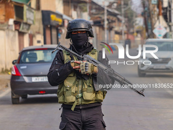 An Indian security personnel guards near the site of a gun battle between militants and security forces on the outskirts of Srinagar, Jammu...