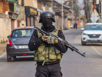 An Indian security personnel guards near the site of a gun battle between militants and security forces on the outskirts of Srinagar, Jammu...