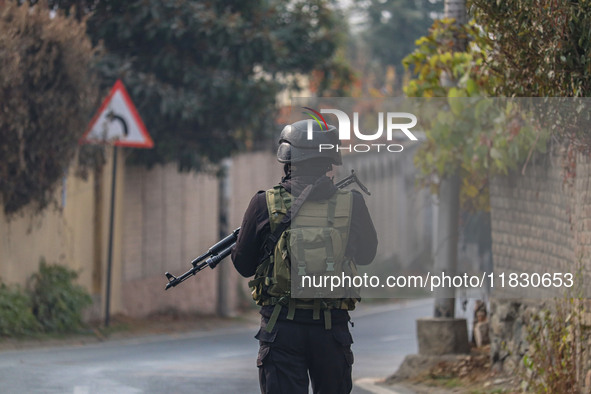 An Indian security personnel guards near the site of a gun battle between militants and security forces on the outskirts of Srinagar, Jammu...