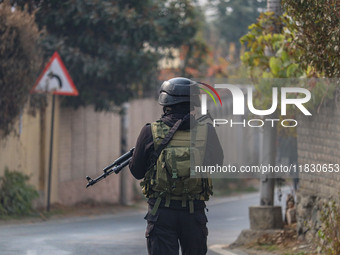 An Indian security personnel guards near the site of a gun battle between militants and security forces on the outskirts of Srinagar, Jammu...