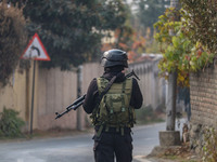 An Indian security personnel guards near the site of a gun battle between militants and security forces on the outskirts of Srinagar, Jammu...