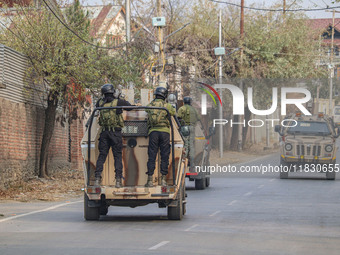 Indian security personnel patrol on armored vehicles near the site of a gun battle between militants and security forces on the outskirts of...