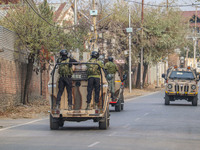 Indian security personnel patrol on armored vehicles near the site of a gun battle between militants and security forces on the outskirts of...