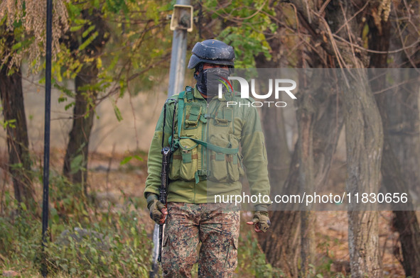 An Indian security personnel is seen near the site of a gun battle between militants and security forces on the outskirts of Srinagar, Jammu...