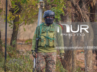 An Indian security personnel is seen near the site of a gun battle between militants and security forces on the outskirts of Srinagar, Jammu...