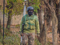 An Indian security personnel is seen near the site of a gun battle between militants and security forces on the outskirts of Srinagar, Jammu...