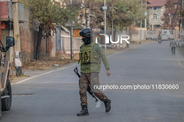 An Indian security personnel is seen near the site of a gun battle between militants and security forces on the outskirts of Srinagar, Jammu...