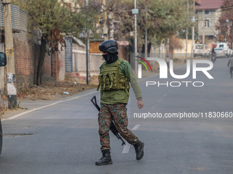 An Indian security personnel is seen near the site of a gun battle between militants and security forces on the outskirts of Srinagar, Jammu...