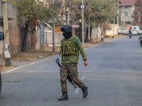 An Indian security personnel is seen near the site of a gun battle between militants and security forces on the outskirts of Srinagar, Jammu...