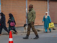 An Indian security personnel guards a road during a gun battle between militants and security forces on the outskirts of Srinagar, Jammu and...