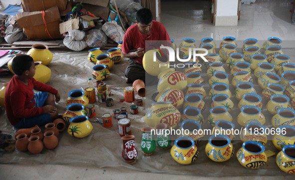 A vendor paints an earthen pot to store ''Joynagar Moa of West Bengal'' (an Indian sweet) made with folk rice mixed with date molasses insid...