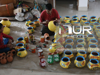 A vendor paints an earthen pot to store ''Joynagar Moa of West Bengal'' (an Indian sweet) made with folk rice mixed with date molasses insid...