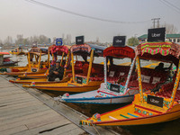 Abdul Razaaq, 70, sits next to Uber ''Shikaras'' or small boats after Uber launches its first water transport service on the waters of Dal L...