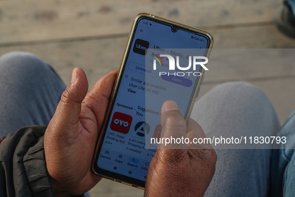 A man downloads the Uber app after Uber launches its first water transport service on the waters of Dal Lake, in Srinagar, Jammu and Kashmir...