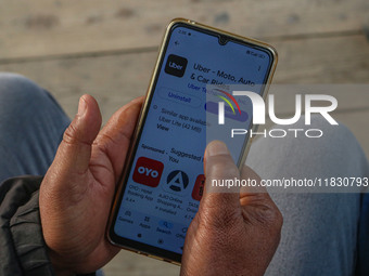 A man downloads the Uber app after Uber launches its first water transport service on the waters of Dal Lake, in Srinagar, Jammu and Kashmir...