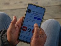 A man downloads the Uber app after Uber launches its first water transport service on the waters of Dal Lake, in Srinagar, Jammu and Kashmir...