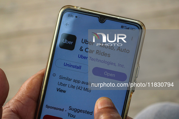 A man downloads the Uber app after Uber launches its first water transport service on the waters of Dal Lake, in Srinagar, Jammu and Kashmir...