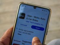 A man downloads the Uber app after Uber launches its first water transport service on the waters of Dal Lake, in Srinagar, Jammu and Kashmir...