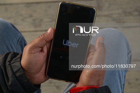 A man uses the Uber app after Uber launches its first water transport service on the waters of Dal Lake, in Srinagar, Jammu and Kashmir, on...