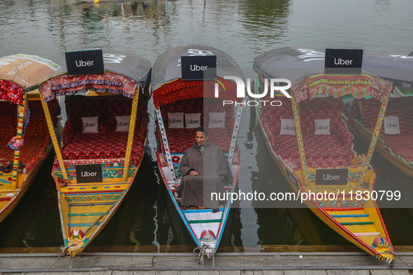 Abdul Rashid Bhat, 55, an Uber boat owner, sits outside his Shikara after Uber launches its first water transport service on the waters of D...