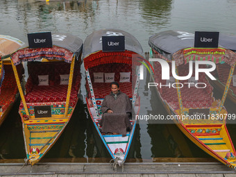 Abdul Rashid Bhat, 55, an Uber boat owner, sits outside his Shikara after Uber launches its first water transport service on the waters of D...