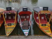 Abdul Rashid Bhat, 55, an Uber boat owner, sits outside his Shikara after Uber launches its first water transport service on the waters of D...