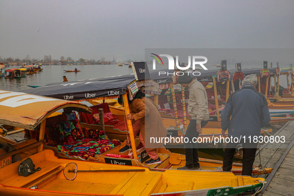 Indian tourists enter the Uber ''Shikara'' or small boat after Uber launches its first water transport service on the waters of Dal Lake, in...