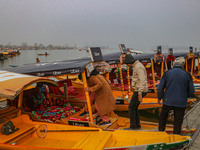 Indian tourists enter the Uber ''Shikara'' or small boat after Uber launches its first water transport service on the waters of Dal Lake, in...