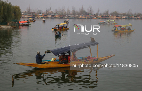 Indian tourists take the Uber ''Shikara'' or small boat ride after Uber launches its first water transport service on the waters of Dal Lake...