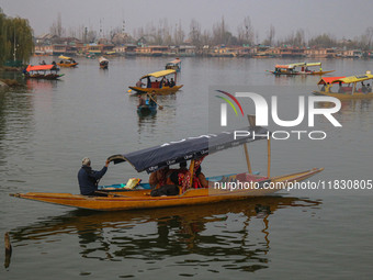 Indian tourists take the Uber ''Shikara'' or small boat ride after Uber launches its first water transport service on the waters of Dal Lake...