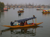 Indian tourists take the Uber ''Shikara'' or small boat ride after Uber launches its first water transport service on the waters of Dal Lake...