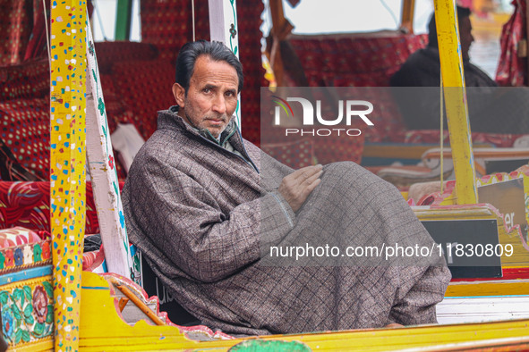 Abdul Rashid Bhat, 55, an Uber boat owner, sits outside his Shikara after Uber launches its first water transport service on the waters of D...