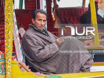 Abdul Rashid Bhat, 55, an Uber boat owner, sits outside his Shikara after Uber launches its first water transport service on the waters of D...