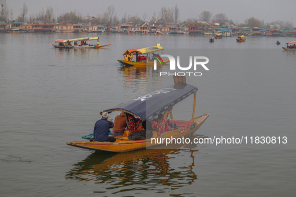 Indian tourists take the Uber ''Shikara'' or small boat ride after Uber launches its first water transport service on the waters of Dal Lake...