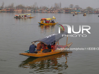 Indian tourists take the Uber ''Shikara'' or small boat ride after Uber launches its first water transport service on the waters of Dal Lake...