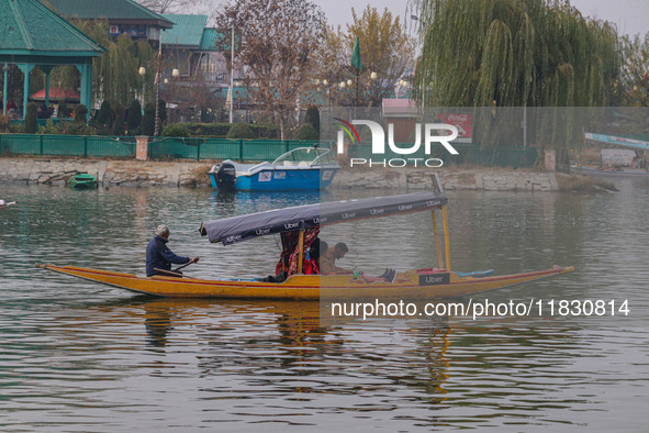 Indian tourists take the Uber ''Shikara'' or small boat ride after Uber launches its first water transport service on the waters of Dal Lake...